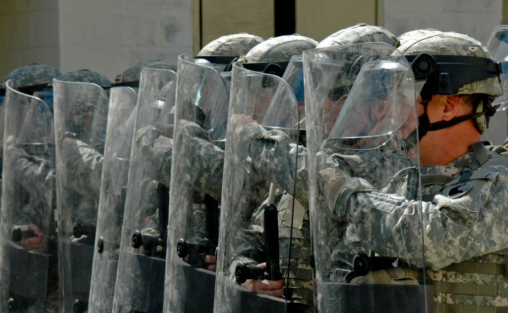image of National Guard members lined up with riot shields, about to suppress free speech rights - Image is in the public domain, see https://vaguard.dodlive.mil/2012/04/15/930/